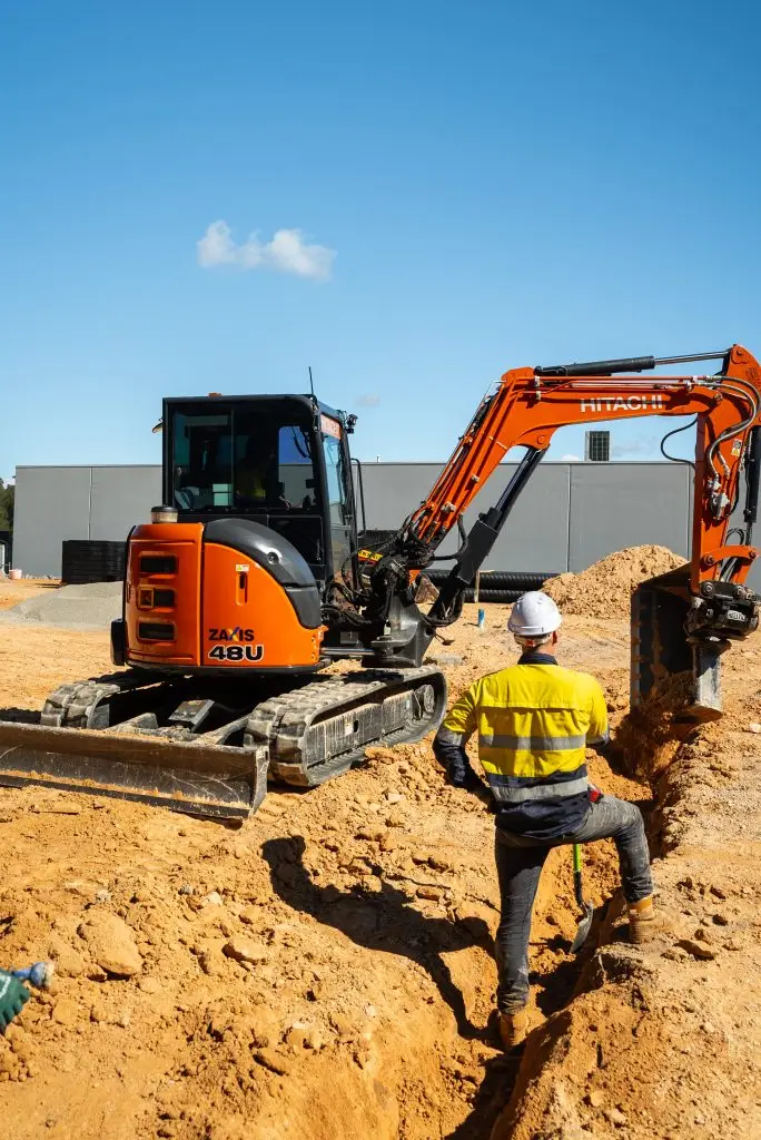 Operator working in a construction site with a mini excavator hire in Brisbane